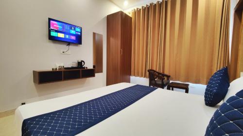 a hotel room with a bed and a flat screen tv at Hotel Park Hills in Mohali