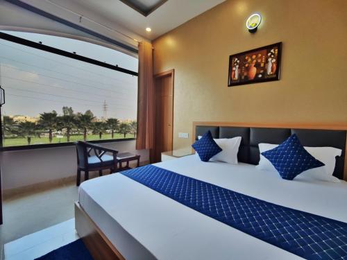 a bedroom with a large bed and a large window at Hotel Park Hills in Mohali