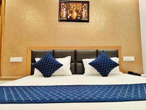 a bed with blue and white pillows on it at Hotel Park Hills in Mohali