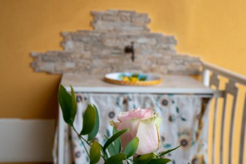 a table with a plate and a flower on it at Acitrezza Casuzza in Aci Castello