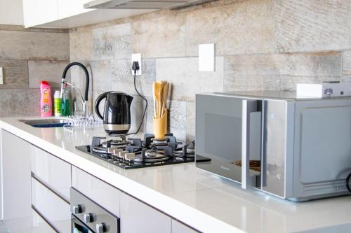 a kitchen with a stove and a microwave at Ongwe Leisure Property in Swakopmund