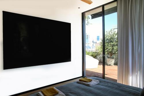 ein Wohnzimmer mit einem Flachbild-TV an der Wand in der Unterkunft 4BDR - Stunning & Magnificent Duplex Penthouse TLV in Tel Aviv