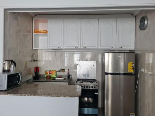 a kitchen with white cabinets and a stainless steel refrigerator at cozy 2 bedroom apartment in Sharm El Sheikh