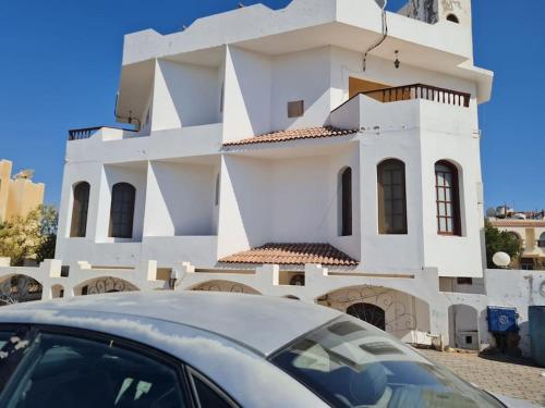 a white building with a car parked in front of it at cozy 2 bedroom apartment in Sharm El Sheikh