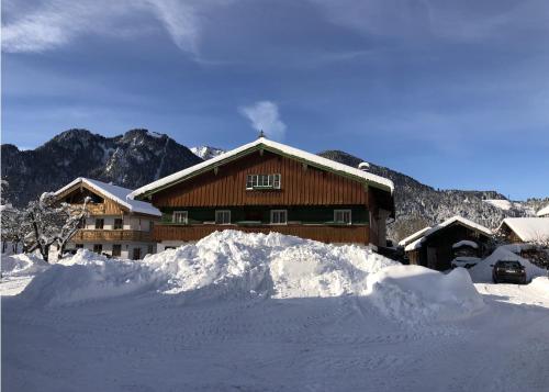 una cabaña de esquí con una pila de nieve delante de ella en NEU: Alpen-Chalet Seekarblick mit Pool, en Lenggries