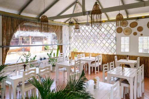 une salle à manger avec des tables et des chaises blanches dans l'établissement JOP, à Ko Chang