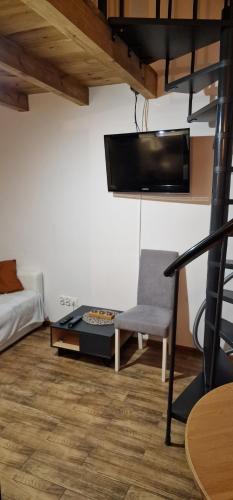 a living room with a couch a chair and a tv at Zimna Apartments in Kwidzyn