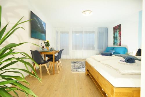 1 dormitorio con 1 cama y 1 mesa con sillas en RELAX - BLUE mit Pool und Sauna, en Scheidegg