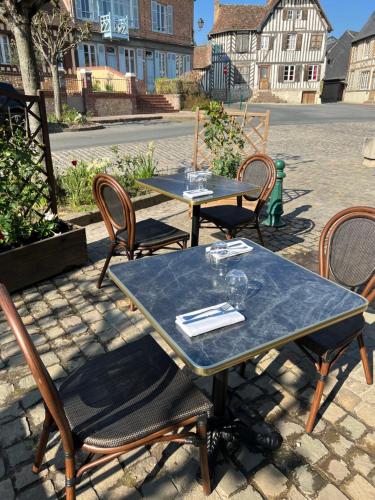 two tables and chairs sitting on a patio at Le Coq Hardi in Blangy-le-Château