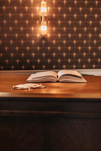 an open book sitting on top of a wooden table at Le Coq Hardi in Blangy-le-Château