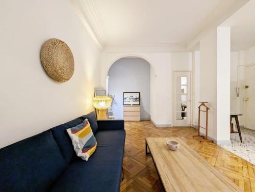 - un salon avec un canapé bleu et une table basse en bois dans l'établissement Promenade des Anglais Negresco, à Nice