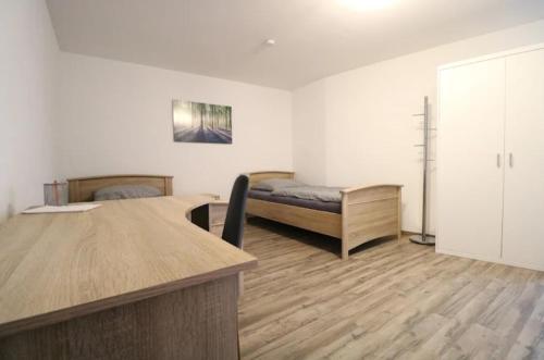 a room with a desk and a bed in a room at Alb Pension Merklingen in Merklingen