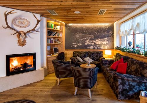 a living room with a couch and a fireplace at Bio Hotel Brusago Vital & Wellness in Bedollo