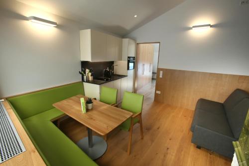 a small room with a wooden table and green chairs at IBY-LEHRNER WEIN-GUT und WEIN-Träumerei in Horitschon