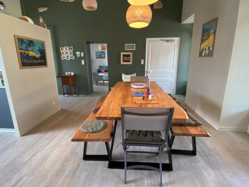 comedor con mesa de madera y silla en Villa Paulownia - à 1,2km des plages - tout confort au coeur du bourg, en Jard-sur-Mer