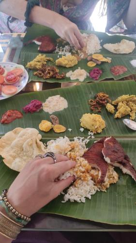 a person on a banana leaf with food on it at Beach Paradise Day Cruise Houseboat in Alleppey