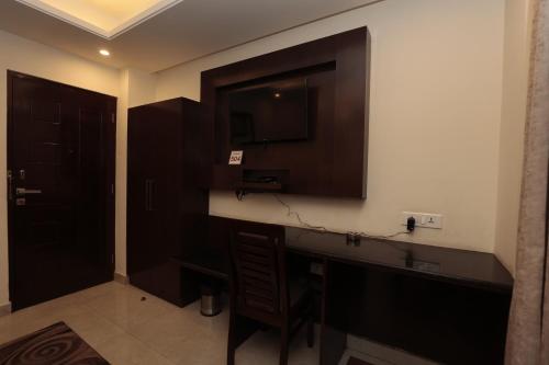 a bathroom with a sink and a television on the wall at Meraki shimla in Shimla