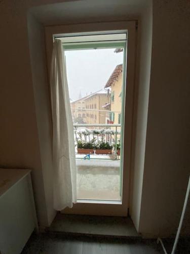 a window in a room with a view of a building at Casi di Lisi, la luce sulla piazza e sulle montagne in Lisignago