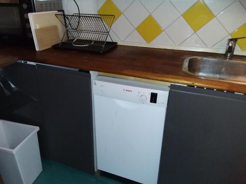 uma cozinha com uma máquina de lavar louça branca e um lavatório em Københavnsvej em Roskilde