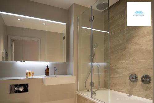 uma casa de banho com uma cabina de duche em vidro e um lavatório. em Stunning 1 Bed apartment at Kings Cross-St Pancras By City Apartments UK Short Lets Serviced Accommodation em Londres