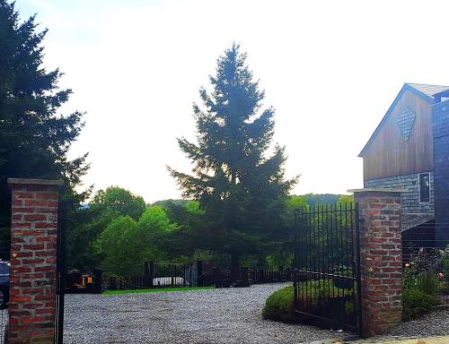 a gate with a tree in front of a house at L'orée du bois in Roy