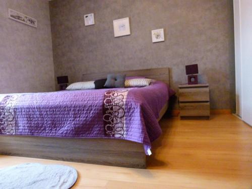um quarto com uma cama roxa com um ursinho de peluche em Lumineuse maison de vacances avec jardin clos em Bussière-Boffy
