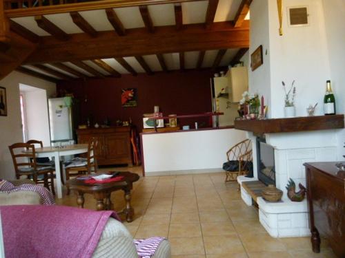 uma sala de estar com uma lareira e uma mesa em Lumineuse maison de vacances avec jardin clos em Bussière-Boffy