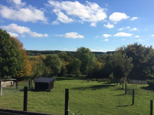 a field with a barn in the middle of it at L'orée du bois in Roy