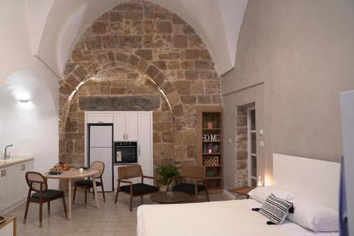 sala de estar con cama y pared de piedra en Beit-sitti, en Acre