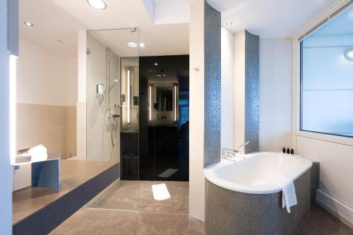 a bathroom with a white sink and a shower at Kongresshotel Potsdam am Templiner See in Potsdam