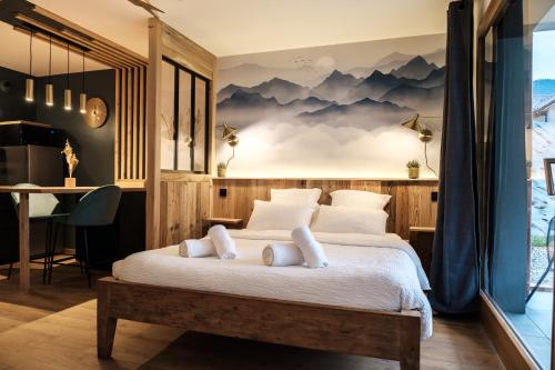 een slaapkamer met een groot bed met bergen aan de muur bij Studio Emeraude - Centre Village - AravisTour in Saint-Jean-de-Sixt