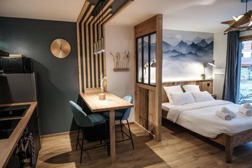 Pokój hotelowy z łóżkiem, stołem i biurkiem w obiekcie Résidence Emeraude - Centre Village - AravisTour w mieście Saint-Jean-de-Sixt