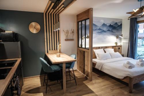 een hotelkamer met een bed, een tafel en een bureau bij Studio Emeraude - Centre Village - AravisTour in Saint-Jean-de-Sixt