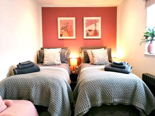 2 camas en una habitación con paredes rojas en Glos Homes Presents - Old Coach House a Quiet Place near Town Centre, en Cheltenham