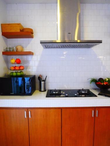 a kitchen with wooden cabinets and a stove top oven at Private Pool Villa 89 Nimman Chiang Mai in Chiang Mai