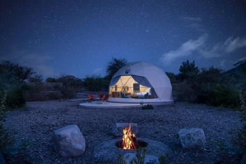 a dome tent with a fire in front of it at night at Hatta Resorts in Hatta