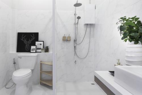 a white bathroom with a shower and a toilet at Private Pool Villa 89 Nimman Chiang Mai in Chiang Mai