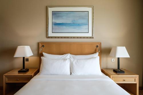 a bed in a hotel room with two lamps at Radisson Blu Resort & Spa, Malta Golden Sands in Mellieħa