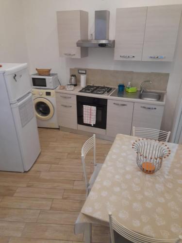 ナポリにあるFlaviogioia Apartmentのテーブルと白い冷蔵庫のあるキッチン