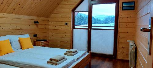 ein Schlafzimmer mit einem Bett in einer Blockhütte in der Unterkunft Sołtysie Chaty - Domek z prywatną balią in Łapsze Niżne