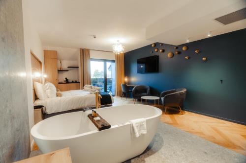 a large bathroom with a tub and a bedroom at Domaine des Thermes in Awans