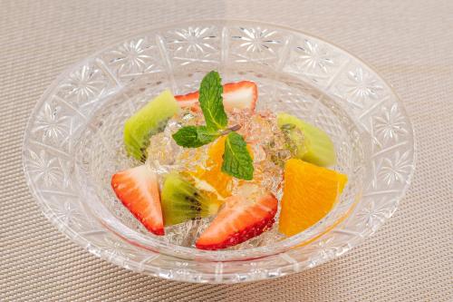 a glass bowl filled with fruit on a table at Ishinoya Izunagaoka - TKP Hotels & Resorts in Izunokuni