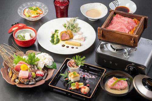 a table topped with plates of food next to a toaster at Ishinoya Izunagaoka - TKP Hotels & Resorts in Izunokuni