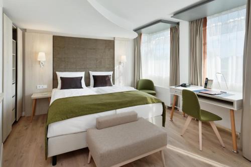 ein Hotelzimmer mit einem Bett, einem Schreibtisch und einem Schreibtisch in der Unterkunft Kongresshotel Potsdam am Templiner See in Potsdam