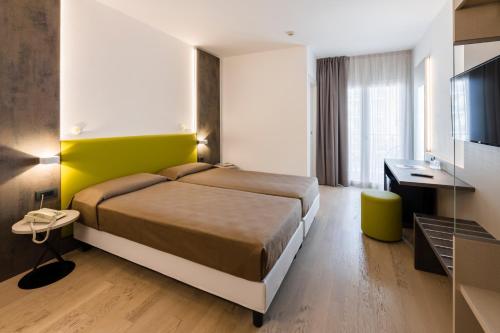 a hotel room with a bed and a television at Hotel Italy in Bibione