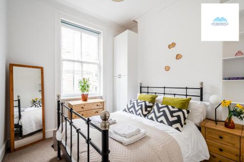 倫敦的住宿－Charming 1 Bed Apartment near British Museum By City Apartments UK Short Lets Serviced Accommodation，卧室配有黑白床和镜子