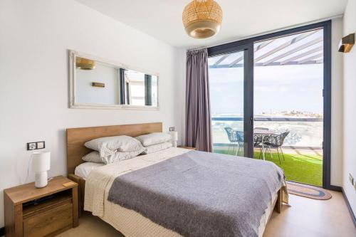 a bedroom with a bed and a view of the ocean at Casa Corralito - 2 bedrooms, rooftop sea view in Cotillo