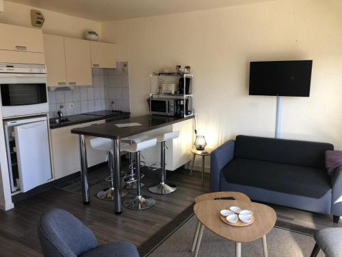 mały salon z kanapą i kuchnią w obiekcie Studio 53 w mieście Le Touquet-Paris-Plage