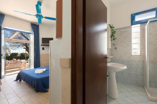 y baño con cama, lavabo y aseo. en Residence La Scogliera by BarbarHouse, en Torre Colimena