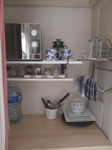 a kitchen with a shelf with utensils on it at The Gift in Agulhas